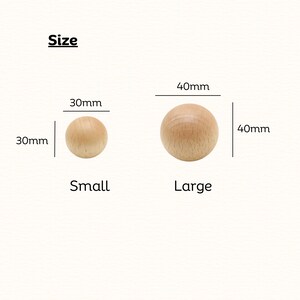 May include: Two light-colored wooden spheres labeled by size. The small sphere is labeled 30mm, and the large sphere is labeled 40mm. The text Size, Small, and Large is present. The spheres have a smooth, natural wood grain finish and round shape.
