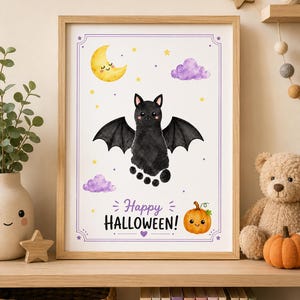 May include: A framed wall art print featuring a black watercolor bat created from a footprint, a yellow crescent moon, purple clouds, and a small orange pumpkin. The text reads Happy HALLOWEEN in purple and black lettering on a white background.