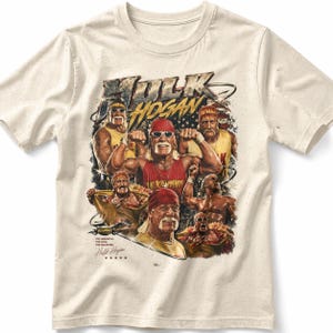 Puede incluir: Camiseta color crema con un gráfico de Hulk Hogan en varias poses. El diseño incluye el texto "Hulk Hogan" en negrita, junto con las frases "The Immortal, The Icon, The Hulkster" y su firma.