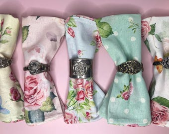 Anillos para servilletas de metal con textura floral y baño de plata vintage para decorar la mesa de tu fiesta.