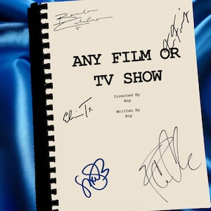 Op de afbeelding: Een crèmekleurig script met de tekst "ANY FILM OR TV SHOW" en meerdere handtekeningen in zwarte en blauwe inkt. Het script is gebonden met een zwarte rug en staat tegen een blauwe satijnen achtergrond.