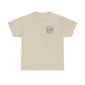 Könnte beinhalten: Beiges T-Shirt mit Rundhalsausschnitt. Das Shirt zeigt den Text "The House ΣΦΕ Ohio Alpha EST. & GREEK" in lila Schrift auf der oberen linken Brust. Das Shirt ist aus weichem Material.