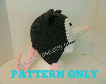 May include: Crochet pattern for a grey and pink opossum hat. The pattern is available for download. "PATTERN ONLY" is written in blue text at the bottom of the image.