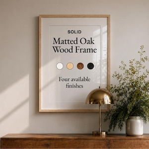 Puede incluir: Un marco de madera de roble con paspartú colgado en una pared. El texto dice: SOLID Matted Oak Wood Frame, Four available finishes, con cuatro muestras de color circulares en blanco, madera clara, madera oscura y negro debajo del texto.