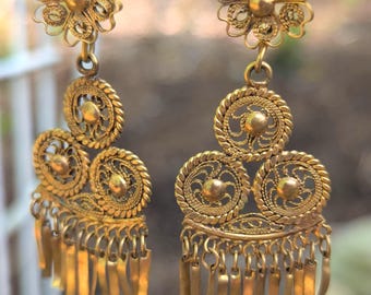 Pendientes mexicanos de filigrana de oro con motivos folclóricos.