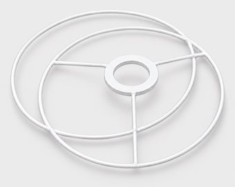 Puede incluir: Una estructura de metal blanco para pantalla de lámpara que consta de dos anillos circulares concéntricos conectados por tres radios rectos a un anillo central. La estructura está hecha de alambre de metal fino, liso y pintado.