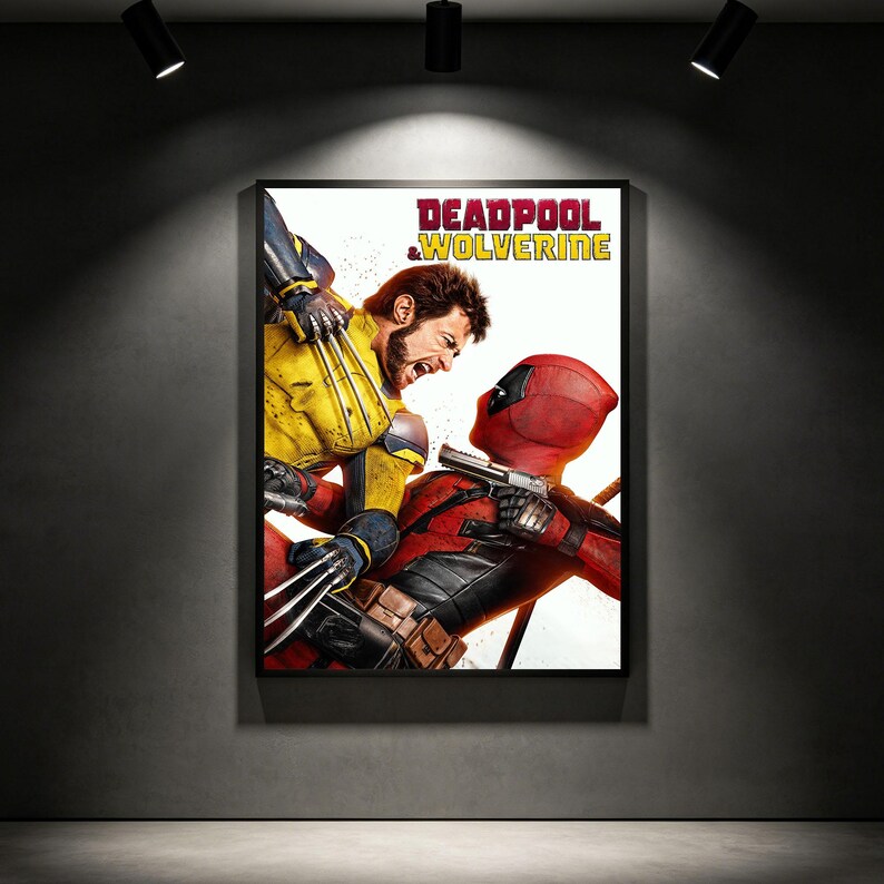 May include: Framed poster depicting Deadpool and Wolverine in combat. Deadpool, in a red suit, holds a gun, facing Wolverine, who is in yellow and blue, with claws extended. The poster's title reads "DEADPOOL & WOLVERINE" in bold letters.