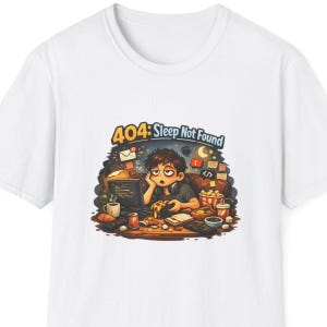 May include: White t-shirt featuring a cartoon illustration of a person looking tired, surrounded by computer equipment and snacks. The text "404: Sleep Not Found" is above the illustration.