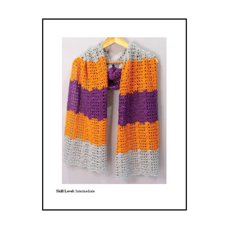 May include: A crochet scarf featuring horizontal stripes in light grey, bright orange, and deep purple. The scarf has an open, lacy stitch pattern and is displayed on a wooden hanger. The text "Skill Level: Intermediate" is printed below.