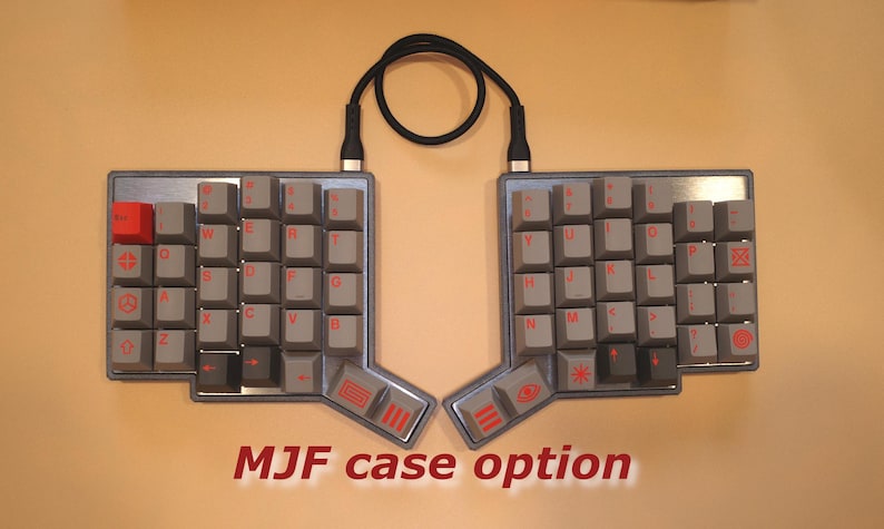 May include: A split ergonomic mechanical keyboard with grey keycaps and red legends. The keyboard features a single red keycap on the left side, a black connecting cable, and a metallic frame. The text MJF case option is printed below the keyboard.