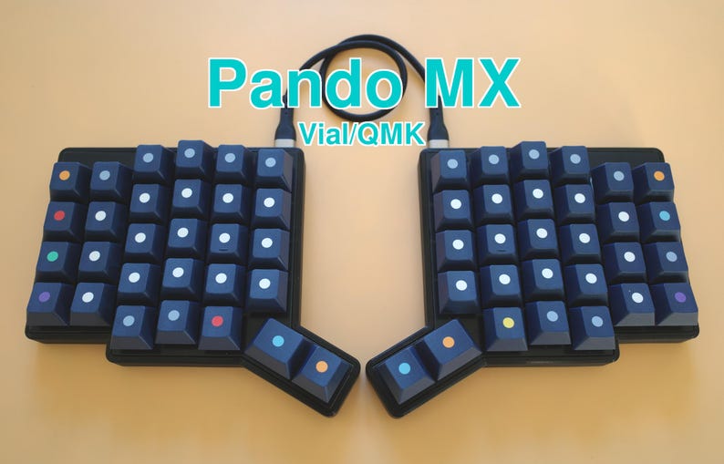 May include: A split ergonomic mechanical keyboard labeled Pando MX Vial/QMK with dark blue keycaps. The keys feature small, centered circular accents in white, orange, red, green, purple, yellow, and light blue. A black cable connects the two halves.