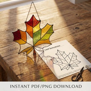Peut inclure: Un capteur de soleil en forme de feuille d'érable en vitrail aux couleurs automnales, rouge, orange, jaune et vert, suspendu par une chaîne. Un patron pour le capteur de soleil est sur papier blanc. Texte : "INSTANT PDF/PNG DOWNLOAD."