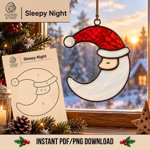 May include: A stained glass ornament shaped like a crescent moon with a Santa face, featuring a red hat, white beard, and black solder lines. Beside it is a paper pattern labelled Sleepy Night with numbered sections for crafting this design.