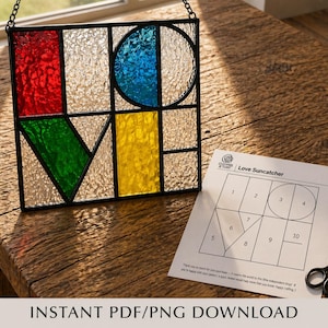 May include: A stained glass suncatcher spelling "LOVE" in red, green, blue, and yellow panels. The suncatcher hangs from a chain. A pattern sheet and small scissors are placed nearby. The text "INSTANT PDF/PNG DOWNLOAD" is at the bottom.