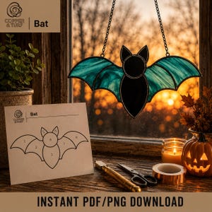 May include: A stained glass bat suncatcher with teal wings and a black body, suspended by a metal chain. Beside it is a paper pattern labeled "Bat" with numbered sections, a glass cutter, a roll of copper foil tape, and a small jack-o'-lantern.