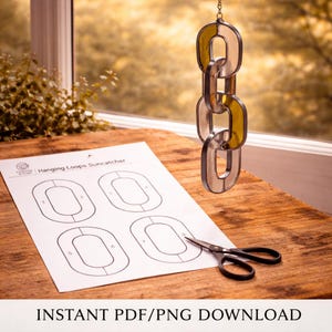 May include: A stained glass suncatcher in a chain link design, with alternating yellow and clear glass sections. A printed template for hanging loops and a pair of scissors are on a wooden surface. The text "INSTANT PDF/PNG DOWNLOAD" is at the bottom.