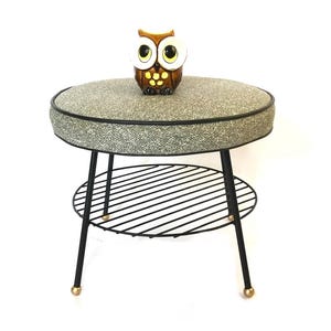 May include: A set of three ceramic mugs with a speckled, cream-colored glaze. Each mug features a different hand-painted floral design in shades of blue, green, and yellow. The mugs have a simple, rounded shape and a comfortable handle.