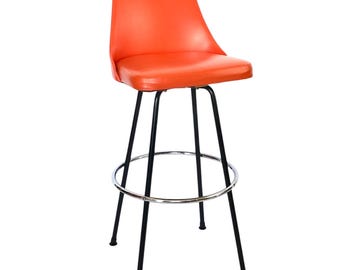 Pode incluir: Banqueta de bar laranja com assento e encosto curvos. A banqueta tem uma estrutura de metal preto com apoio para os pés e quatro pernas. O assento é feito de um material liso e brilhante.