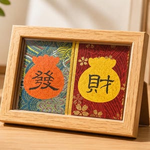 Op de afbeelding: Een houten kunstwerk met twee panelen. Elk paneel heeft een kleurrijk ontwerp van een geldbuidel met Chinese karakters. Het linkerpaneel heeft een oranje tas op een blauwe en groene achtergrond. Het rechterpaneel heeft een gele tas op een rode achtergrond.