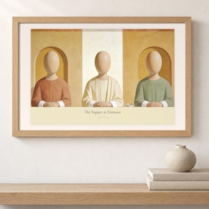 Shelf mockup of The Supper at Emmaus in a light oak frame resting on a pale wood surface beside stacked neutral books and a rounded ceramic vase. The framed print shows Christ seated at the center of a supper table within warm rounded niches. Cream matting, soft wall texture, and natural light present the horizontal Bible artwork at an easy domestic scale.