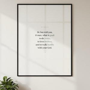Micah 6:8 wall art hanging in black glass frame on warm white living room wall above mid-century console with plant. He has told you O man what is good to do justice to love kindness and to walk humbly with your God ESV. Sage green scripture print Christian Father Day graduation confirmation gift. Digital download printable bible verse for home office study bedroom gallery wall decor from TheFramedVerse