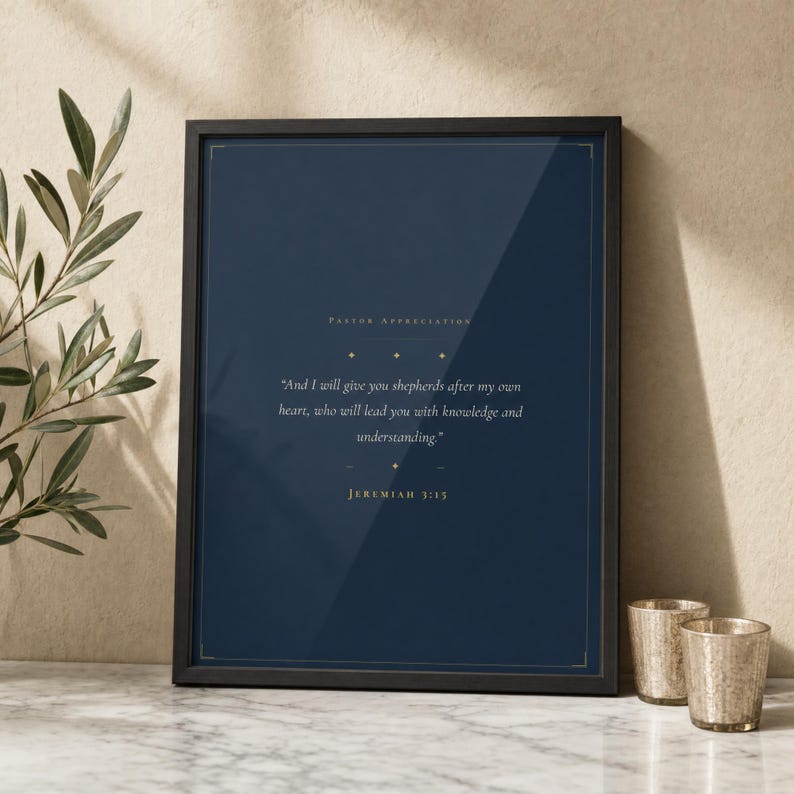 Jeremiah 3:15 Shepherds After My Own Heart scripture print in thin black frame on white Carrara marble, single sage olive branch and two unlit votive candles, warm textured wall, bright morning light with glass reflection, still life editorial pastor appreciation christian print digital download by TheFramedVerse