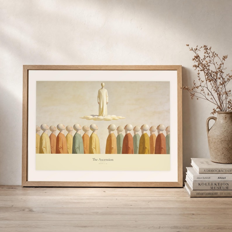 Leaning frame mockup of The Ascension on a rustic wood console beside stacked art books and a tall ceramic vessel with dried stems. The print shows Christ standing in light above a soft cloud while gathered witnesses look upward. The oak frame, broad cream mat, plaster wall, and soft side light create a relaxed display while keeping the title and Acts 1:9 legible.
