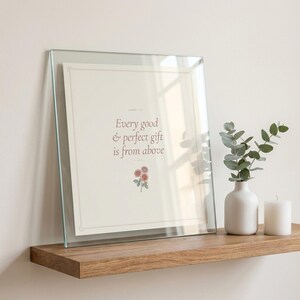 Every Good and Perfect Gift James 1 17 Wall Art Coquette Christian Print Blush B — room setting mockup in cozy living space with complementary decor. This coquette bow, botanical, pink blush christian scripture wall art print features beautiful serif typography on warm cream background. James 1 17 bible verse digital download printable for home office bedroom living room gallery wall decor. Per...