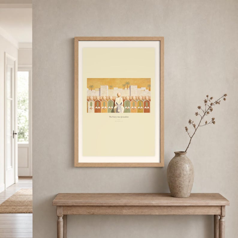 Room mockup of The Entry into Jerusalem displayed in a light oak frame on a warm neutral wall. The landscape artwork shows the entry into Jerusalem, with a crowd of faceless figures raising flat palm fronds along the city wall. A wide cream mat and restrained fresco palette suit a calm living room, prayer space, or Christian home. The printed title and Matthew 21:9 remain visible beneath the image.