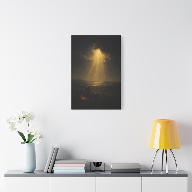 Dark vintage oil painting showing shepherds with their flock around a glowing campfire at night. Heavenly rays break through dramatic clouds above distant Bethlehem and illuminate the hills, forming a peaceful, reverent Christmas scene. Luke 2:14 wall art in deep blue, brown, and gold, printed on stretched canvas. This straight product presentation shows the full image and canvas proportions.