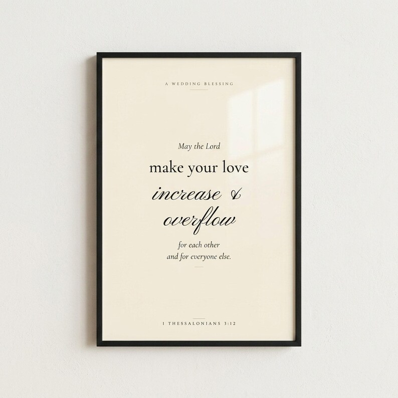 1 Thessalonians 3:12 'May the Lord Make Your Love Increase' Christian wedding wall art print in thin black metal frame, frontal view on off-white textured wall, modern minimalist styling with soft top light and gentle shadow below frame, e-commerce hero photograph, instant download from TheFramedVerse