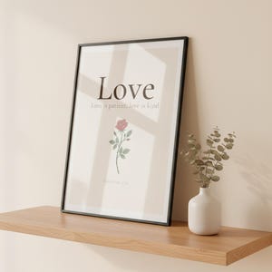 Love Fruit of the Spirit Christian wall art print featuring Galatians 5:22, with beautiful red rose botanical illustration, in minimalist botanical watercolor illustration on warm cream background with elegant serif typography, showcased in an elegant contemporary home interior with curated decor elements, demonstrating how this Christian art piece elevates any living space