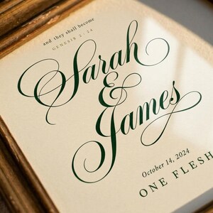 Hero view of the framed design, clearly showing the verse lettering, balanced spacing, and refined color palette. The One Flesh artwork features Genesis 2:24 with custom names and a wedding date in elegant forest green script on warm beige. This Genesis 2:24 personalized wedding gift suits an anniversary, bridal shower, newlywed bedroom, or meaningful Christian home display.