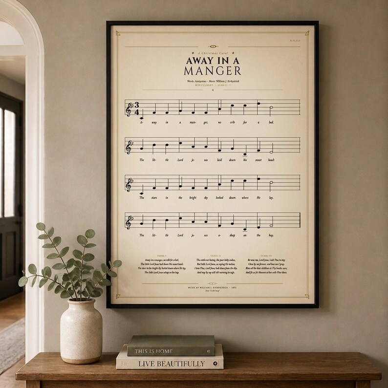 Away in a Manger single vintage hymn print in a thin black metal frame, frontal view on an off-white textured wall, modern classical Christmas arrangement with soft top light and gentle shadow. Holiday Christian sheet music wall art digital download from TheFramedVerse, Luke 2:7 hymnal page in cream and antique sepia.