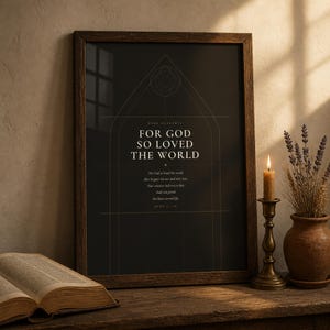 Dark Academia John 3:16 scripture print leaning on a walnut shelf styled with dark academic props — stacked books, candle and greenery. For God So Loved the World Bible verse art in gothic arch design. Moody Christian wall art digital download perfect as confirmation or housewarming gift.
