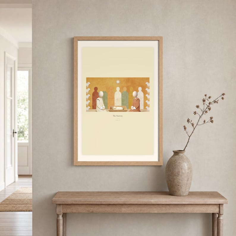 Room mockup of The Nativity displayed in a light oak frame on a warm neutral wall. The landscape artwork shows the wrapped child in a low manger between two kneeling figures, beneath a single star. A wide cream mat and restrained fresco palette suit a calm living room, prayer space, or Christian home. The printed title and Luke 2:7 remain visible beneath the image.