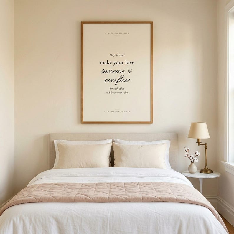 1 Thessalonians 3:12 modern Christian wedding wall art print framed in oak above a cream velvet sofa with linen throw and ivory pillows, side table with ceramic mug and open book, cottage farmhouse Christian newlywed living room, soft afternoon light, digital download from TheFramedVerse Etsy