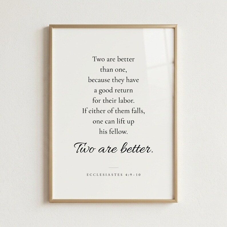 Studio front shot of Ecclesiastes 4:9-10 'Two Are Better Than One' wedding scripture print in refined champagne gold metal frame on soft warm white wall. Editorial product photography — Christian wedding wall art, newlywed gift, first anniversary, engagement present, bridal shower keepsake, instant download.