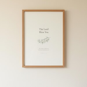 The Lord Bless You Numbers 6 24 26 Nursery Bible Verse Print Christian Wall Art, in gentle sage green nursery design with soft botanical watercolor illustration and calming earth tones, displayed in a calm nursery setting with soft natural light, wooden baby furniture and gentle earth-toned decor creating a tranquil environment