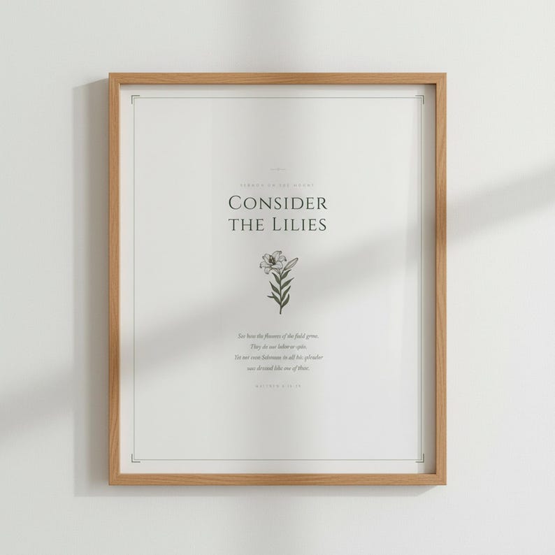 Consider the Lilies Matthew 6:28 sage green botanical scripture art print in thin gold frame, frontal studio shot on cream wall, warm natural daylight from left, elegant bible print minimalist christian style, digital download for gallery wall pairing, TheFramedVerse Etsy shop scripture printable