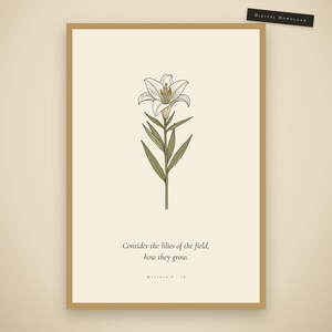 Matthew 6:28 consider the lilies of the field bible verse wall art in gold frame on warm cream wall. Vintage botanical wildflower scripture print featuring hand-drawn white lily with modern christian typography. Part of 6-print digital download set f