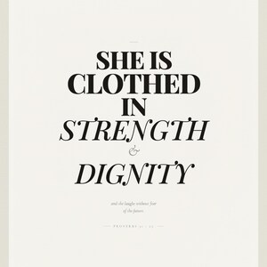 Proverbs 31 25 Wall Art She is Clothed in Strength and Dignity Scripture Print, in elegant Mother's Day design with soft pink watercolor botanical flowers and graceful serif typography, displayed in a bright modern entryway next to a coat rack with natural greenery, serving as welcoming faith-filled home decor