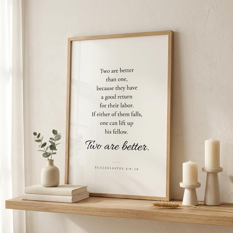 Ecclesiastes 4:9-10 'Two Are Better Than One' Christian wedding wall art in oak frame on floating shelf beside white peonies in ceramic vase, cream linen books, and pillar candles. Romantic Christian newlywed home interior. Perfect wedding gift, anniversary, bridal shower print, instant digital download.
