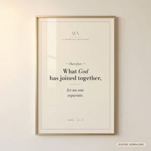 Mark 10:9 modern Christian wedding scripture print in solid walnut frame, frontal studio shot on cream backdrop with soft top-left key light, glass reflection visible, e-commerce hero photograph, 'What God Has Joined Together' marriage gift digital download by TheFramedVerse