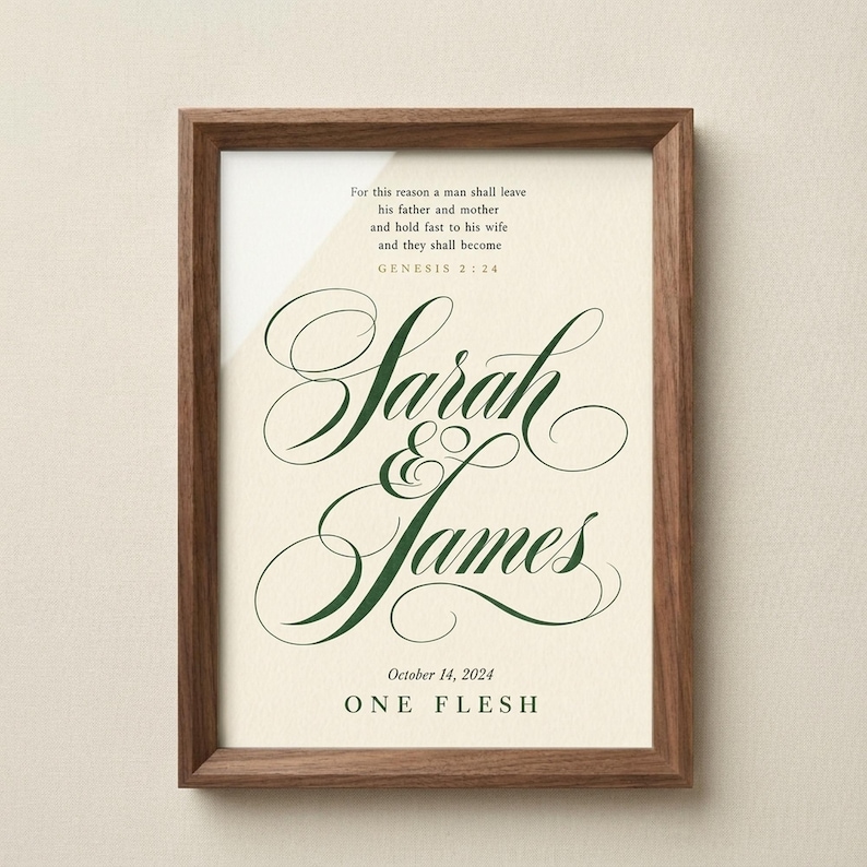 Warm lifestyle room with the framed design on a soft cream wall beside neutral decor and natural window light. The One Flesh artwork features Genesis 2:24 with custom names and a wedding date in elegant forest green script on warm beige. This Genesis 2:24 personalized wedding gift suits an anniversary, bridal shower, newlywed bedroom, or meaningful Christian home display.