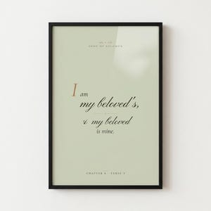 Song of Solomon 6:3 'I Am My Beloved's' coquette sage Christian wedding scripture print in thin gold metal frame, frontal view on warm off-white textured wall, romantic feminine styling with soft top light and gentle shadow below frame, e-commerce hero photograph, instant download from TheFramedVerse