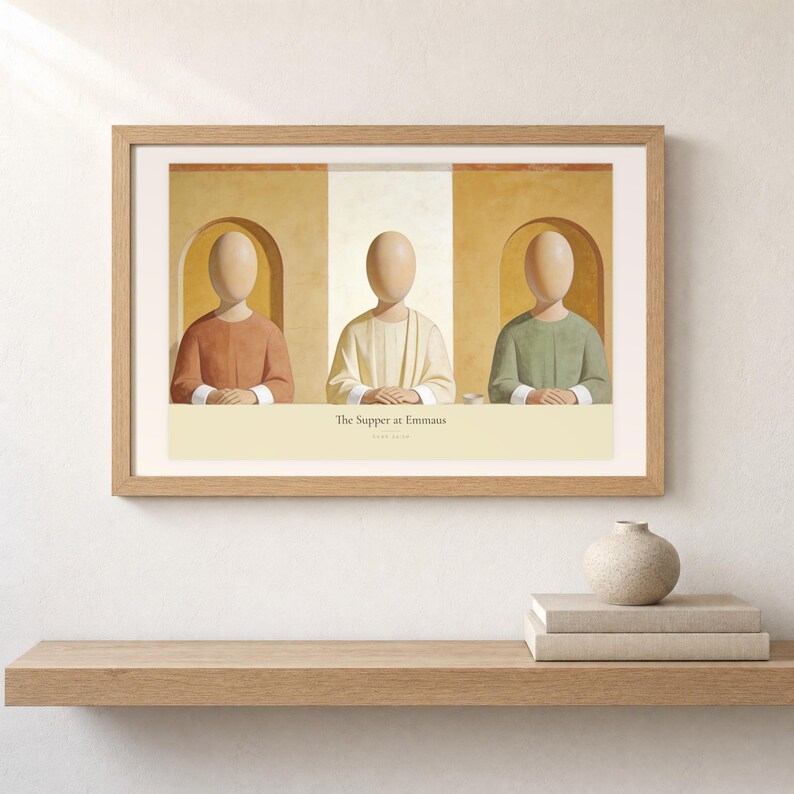 Shelf mockup of The Supper at Emmaus in a light oak frame resting on a pale wood surface beside stacked neutral books and a rounded ceramic vase. The framed print shows Christ seated at the center of a supper table within warm rounded niches. Cream matting, soft wall texture, and natural light present the horizontal Bible artwork at an easy domestic scale.