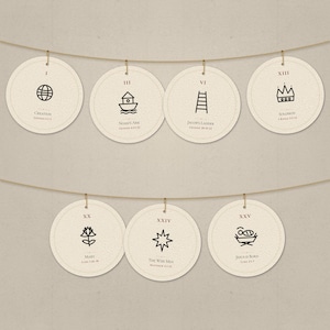 May include: A decorative garland featuring seven circular off-white paper ornaments suspended from a thin twine string. Each ornament displays a black line-art icon, a Roman numeral, and text referencing biblical events like Creation and Jesus Is Born.