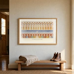 Room mockup of The Shepherds and the Angels from the Christmas story set, in a light oak frame on a warm wall. The artwork shows a row of angels above shepherds and their sheep, with a star set between the two groups. The horizontal format and cream matting present the second print of the gallery wall set.