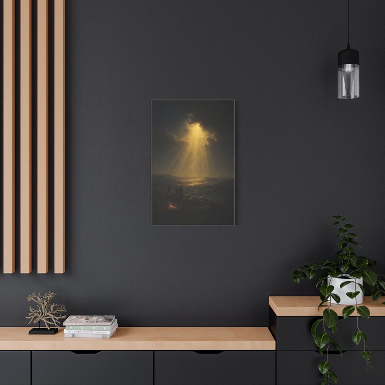 Shepherds and their flock rest beside a glowing nighttime campfire as heavenly light breaks through clouds over distant Bethlehem. The dark vintage oil painting renders the illuminated hills in deep blue, brown, and gold with a peaceful, reverent mood. This Luke 2:14 Christmas wall art is printed on stretched canvas. An alternate angle provides a product view of the wrapped canvas construction.